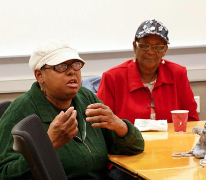 有色人种女性坐在桌子旁谈论她们的权益优先事项.